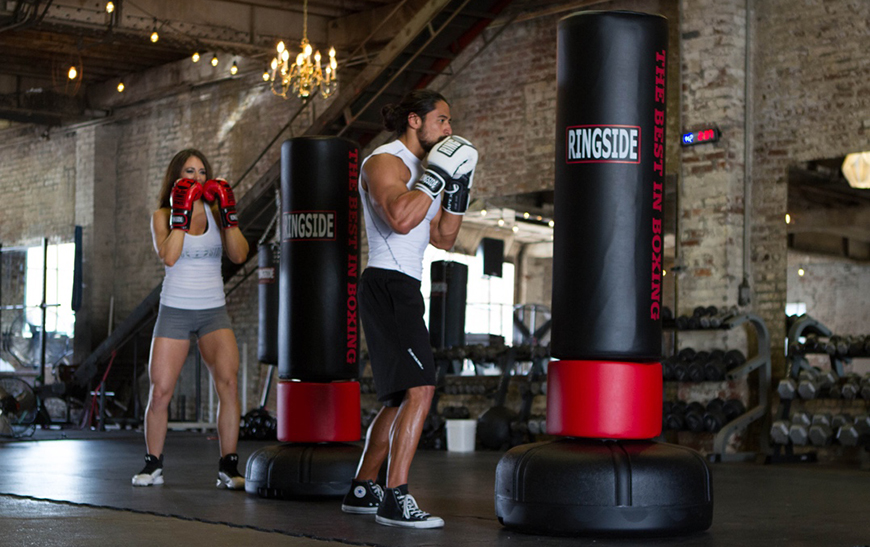 pair of athletes punching freestanding heavy bags