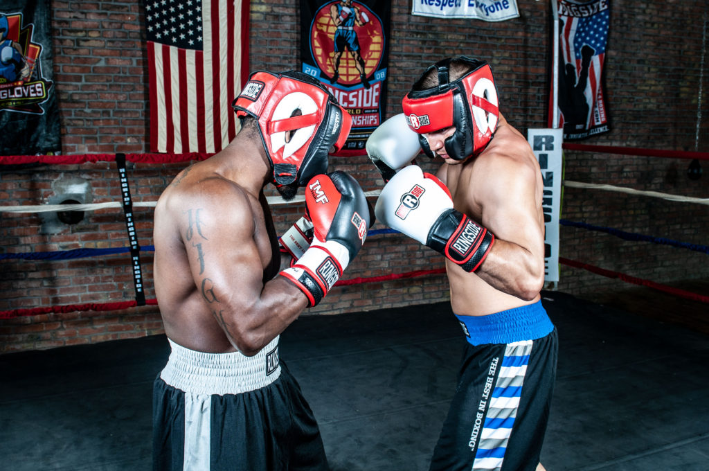 Two boxers test each other while sparring.