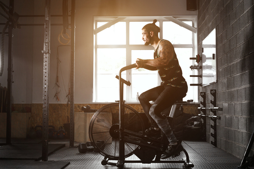 young man using exercise bike at the gym