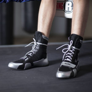 Black and silver ringside boxing shoots on the feet of a boxer.
