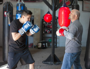 A boxer prepares to hit the mitts with his boxing coach
