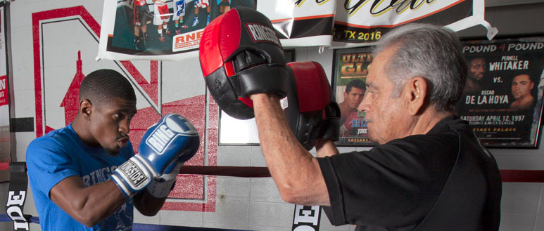 holding the boxing mitts for a fighter in the ring