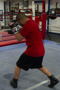 A fighter re-positions his feet while shadowboxing