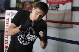 Shadowboxing with black hand wraps in the ring.