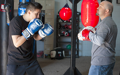 Coach with punch mitts discusses the upcoming training session before beginning.