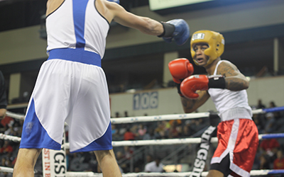 A boxer throws a jab at his opponent to maintain separation.