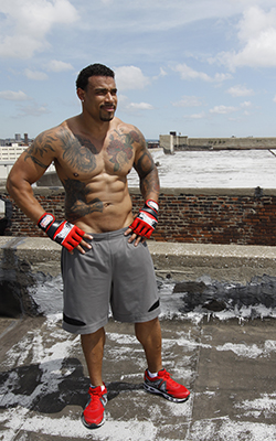 A fighter stands on a rooftop appreciating the good weather and the spectacular view.