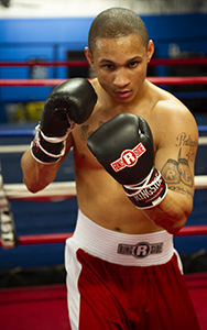 A lean boxer in the middle of the ring engaged in a shadowboxing routine.